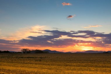 Sunset over the harvested field in hungary with colorful sky