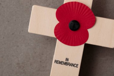 A red remembrance poppy on a wooden cross. Military remembrance day concept clipart