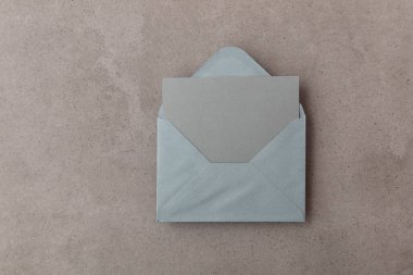 Gri kâğıt şablonu olan boş gri kart beton arka planda maket yapıyor.