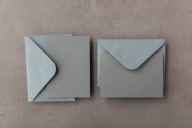 Gri kâğıt şablonu olan boş gri kart beton arka planda maket yapıyor.