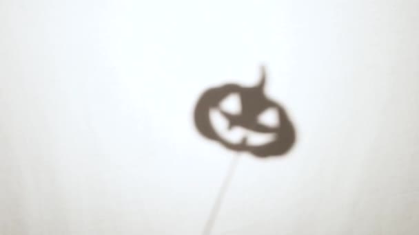 Halloween-Kürbis-Schattenpuppen auf Stöcken hinter einem weißen Laken — Stockvideo