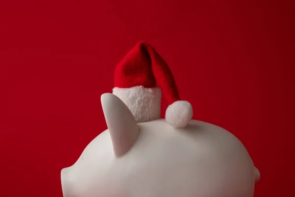 Kerst sparen, White piggy bank geld doos met een rode kerstman hoed — Stockfoto