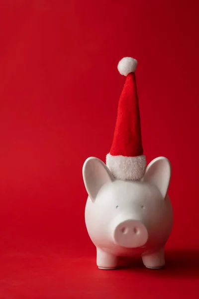 Vánoční spoření, Bílé prasátko bankovní peníze box na sobě červený Santa Claus klobouk — Stock fotografie