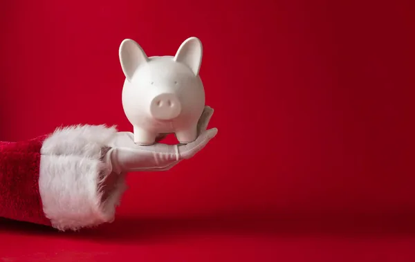 크리스마스 돼지 저금통을 들고 있는 산타 클로스. 절약이라는 개념 — 스톡 사진