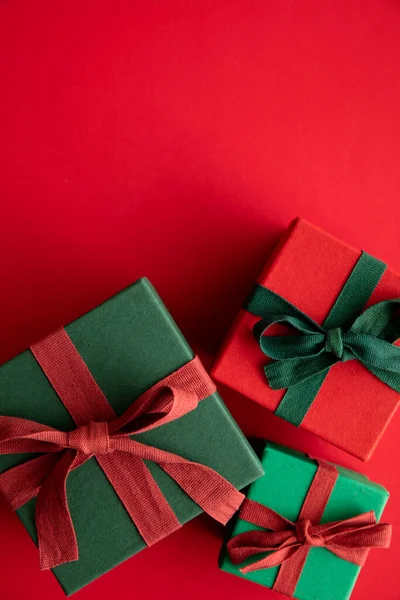 Εορταστικό χριστουγεννιάτικο δώρο κουτί δώρο δεμένο με μια ρουστίκ κορδέλα και τόξο σε ένα κόκκινο φόντο. Εναέρια προβολή — Φωτογραφία Αρχείου