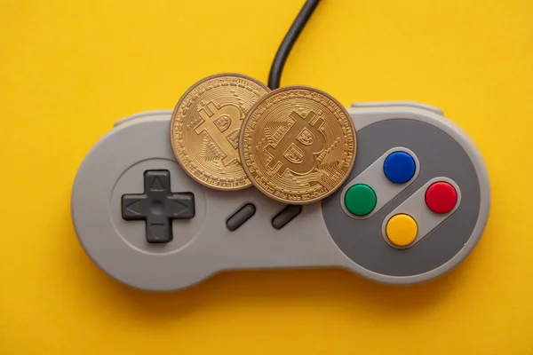 Concepto de juego Crypto. Controlador de videojuegos con una moneda criptomoneda bitcoin —  Fotos de Stock