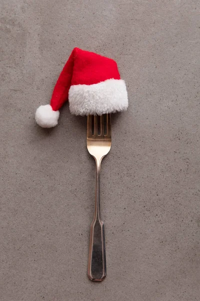 Christmas food background. Fork utensil wearing a festive father Christmas hat — Stock Photo, Image