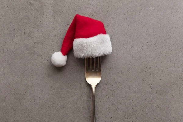 Christmas food background. Fork utensil wearing a festive father Christmas hat — Stock Photo, Image