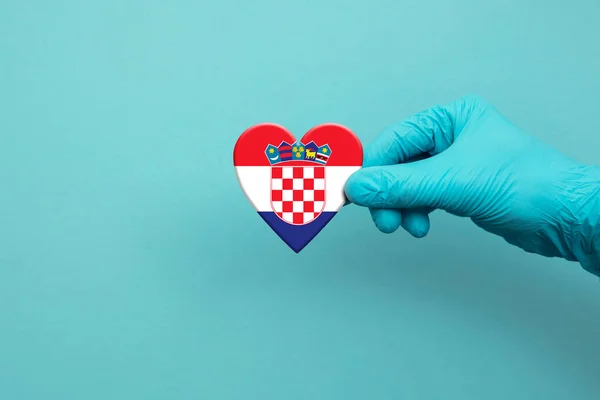 Οι γιατροί φορούν χειρουργικό γάντι κρατώντας την καρδιά της Κροατίας σημαία — Φωτογραφία Αρχείου