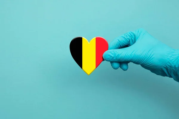 医务工作者手拿着印有比利时国旗的外科手套 — 图库照片