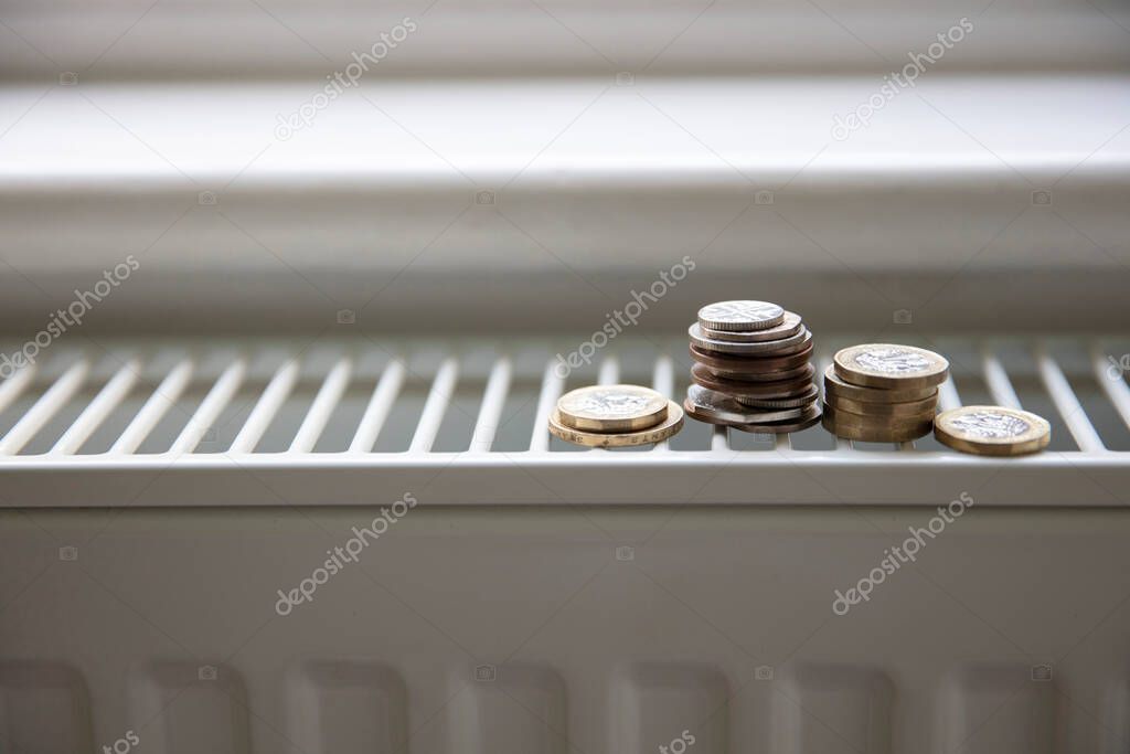 Cost of living crisis. Money on a home radiator heater. Rising cost of energy and bills.