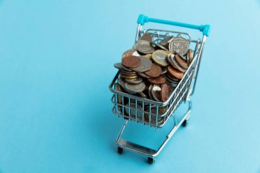 Shopping cart full of UK sterling coins. Cost of shopping concept.