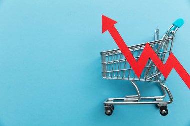 Rising cost of shopping. Shopping cart with red inflation arrow.