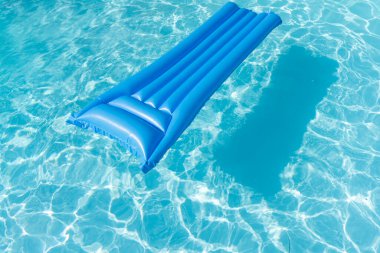 Parlak mavi yaz havuzu dalgalı yüzme havuzunda yüzüyor..