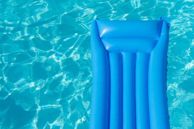 Parlak mavi yaz havuzu dalgalı yüzme havuzunda yüzüyor..