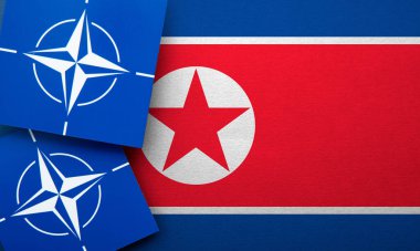LONDON, UK - August 2022: NATO North Atlantic Treaty Organization military alliance logo on a North Korea flag.