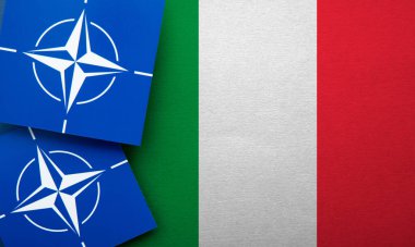 LONDON, UK - August 2022: NATO North Atlantic Treaty Organization military alliance logo on a Italy flag.