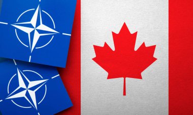 LONDON, UK - August 2022: NATO North Atlantic Treaty Organization military alliance logo on a Canada flag.