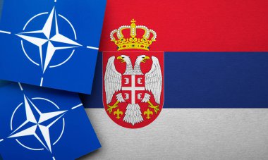 LONDON, UK - August 2022: NATO North Atlantic Treaty Organization military alliance logo on a Serbia flag.