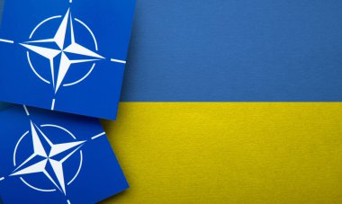 LONDON, UK - August 2022: NATO North Atlantic Treaty Organization military alliance logo on a Ukraine flag.