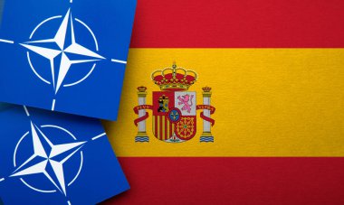 LONDON, UK - August 2022: NATO North Atlantic Treaty Organization military alliance logo on a Spain flag.