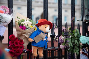 LONDON, UK - September 2022: Paddington Bear toy on the gates of Buckingham Palace in tribute to Queen Elizabeth II after her death. clipart