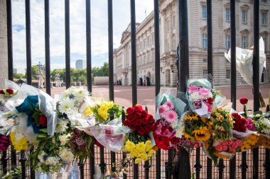 LONDON, İngiltere - Eylül 2022: Kraliçe 2. Elizabeth anısına Buckingham Sarayı 'nın kapılarında çiçekler.