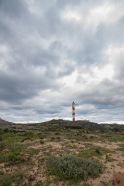 Volkanik kayalar, deniz feneri ve fırtına bulutlarıyla çöl manzarası. Aabdes, Tenerife, Kanarya Adaları. İspanya