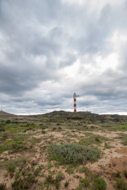 Volkanik kayalar, deniz feneri ve fırtına bulutlarıyla çöl manzarası. Aabdes, Tenerife, Kanarya Adaları. İspanya