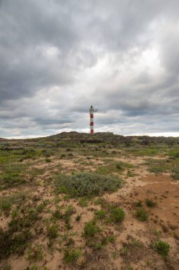 Volkanik kayalar, deniz feneri ve fırtına bulutlarıyla çöl manzarası. Aabdes, Tenerife, Kanarya Adaları. İspanya