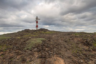 Volkanik kayalar, deniz feneri ve fırtına bulutlarıyla çöl manzarası. Aabdes, Tenerife, Kanarya Adaları. İspanya