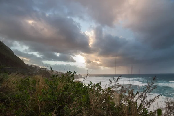 夕阳西下 陡峭的大海从悬崖上掠过 浪花汹涌 许多白色的泡沫冲刷着海岸 暴风雨般的云彩和风景如画的渔村 Bajamar Tenerife 加那利群岛 西班牙 — 图库照片