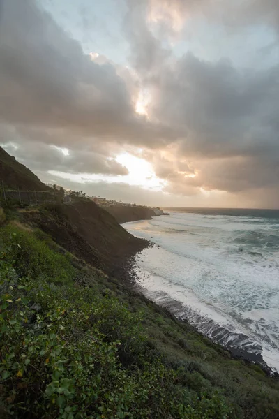 夕阳西下 陡峭的大海从悬崖上掠过 浪花汹涌 许多白色的泡沫冲刷着海岸 暴风雨般的云彩和风景如画的渔村 Bajamar Tenerife 加那利群岛 西班牙 — 图库照片