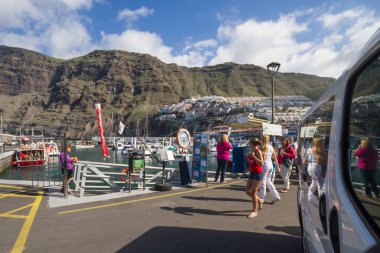 Los Gigantes İskelesi, insanlar balina izlemek için tekneye binmek için rıhtımda yürüyor. Tenerife, Kanarya Adaları. İspanya