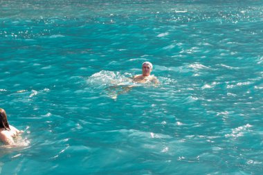 Bir grup insan, turistler, arka planda bir uçurumla Atlantik Okyanusu 'nun turkuaz sularında yüzüyorlar. Los Gigantes, Tenerife, Kanarya Adaları. İspanya