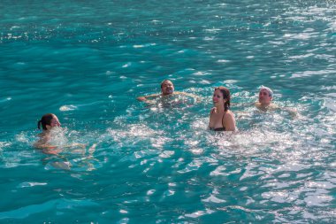 Bir grup insan, turistler, arka planda bir uçurumla Atlantik Okyanusu 'nun turkuaz sularında yüzüyorlar. Los Gigantes, Tenerife, Kanarya Adaları. İspanya