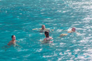 Bir grup insan, turistler, arka planda bir uçurumla Atlantik Okyanusu 'nun turkuaz sularında yüzüyorlar. Los Gigantes, Tenerife, Kanarya Adaları. İspanya