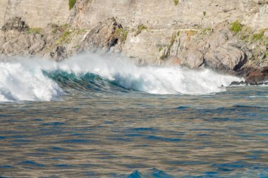 Bol köpüklü dalgalar, Atlantik Okyanusu 'nun volkanik siyah kumlu sahilinde, arka planda kayaları ve kayaları gören dalgalar. Los Gigantes, Tenerife, Kanarya Adaları 'ndan Cliff. İspanya