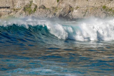 Bol köpüklü dalgalar, Atlantik Okyanusu 'nun volkanik siyah kumlu sahilinde, arka planda kayaları ve kayaları gören dalgalar. Los Gigantes, Tenerife, Kanarya Adaları 'ndan Cliff. İspanya