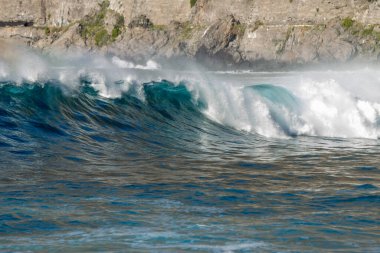 Bol köpüklü dalgalar, Atlantik Okyanusu 'nun volkanik siyah kumlu sahilinde, arka planda kayaları ve kayaları gören dalgalar. Los Gigantes, Tenerife, Kanarya Adaları 'ndan Cliff. İspanya