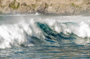 Bol köpüklü dalgalar, Atlantik Okyanusu 'nun volkanik siyah kumlu sahilinde, arka planda kayaları ve kayaları gören dalgalar. Los Gigantes, Tenerife, Kanarya Adaları 'ndan Cliff. İspanya