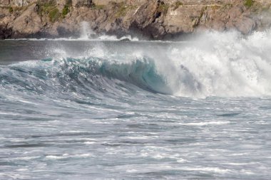 Bol köpüklü dalgalar, Atlantik Okyanusu 'nun volkanik siyah kumlu sahilinde, arka planda kayaları ve kayaları gören dalgalar. Los Gigantes, Tenerife, Kanarya Adaları 'ndan Cliff. İspanya