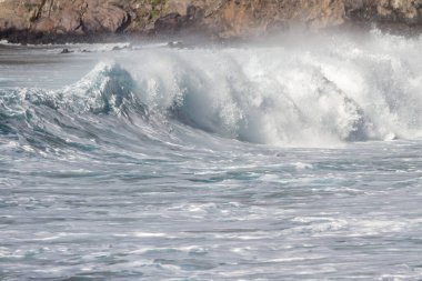 Bol köpüklü dalgalar, Atlantik Okyanusu 'nun volkanik siyah kumlu sahilinde, arka planda kayaları ve kayaları gören dalgalar. Los Gigantes, Tenerife, Kanarya Adaları 'ndan Cliff. İspanya