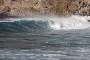 Bol köpüklü dalgalar, Atlantik Okyanusu 'nun volkanik siyah kumlu sahilinde, arka planda kayaları ve kayaları gören dalgalar. Los Gigantes, Tenerife, Kanarya Adaları 'ndan Cliff. İspanya