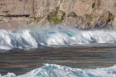 Bol köpüklü dalgalar, Atlantik Okyanusu 'nun volkanik siyah kumlu sahilinde, arka planda kayaları ve kayaları gören dalgalar. Los Gigantes, Tenerife, Kanarya Adaları 'ndan Cliff. İspanya