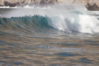 Bol köpüklü dalgalar, Atlantik Okyanusu 'nun volkanik siyah kumlu sahilinde, arka planda kayaları ve kayaları gören dalgalar. Los Gigantes, Tenerife, Kanarya Adaları 'ndan Cliff. İspanya