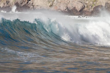 Bol köpüklü dalgalar, Atlantik Okyanusu 'nun volkanik siyah kumlu sahilinde, arka planda kayaları ve kayaları gören dalgalar. Los Gigantes, Tenerife, Kanarya Adaları 'ndan Cliff. İspanya