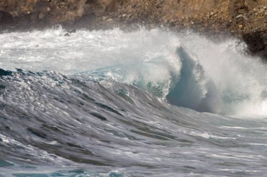 Bol köpüklü dalgalar, Atlantik Okyanusu 'nun volkanik siyah kumlu sahilinde, arka planda kayaları ve kayaları gören dalgalar. Los Gigantes, Tenerife, Kanarya Adaları 'ndan Cliff. İspanya