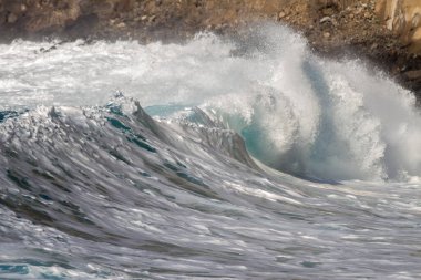 Bol köpüklü dalgalar, Atlantik Okyanusu 'nun volkanik siyah kumlu sahilinde, arka planda kayaları ve kayaları gören dalgalar. Los Gigantes, Tenerife, Kanarya Adaları 'ndan Cliff. İspanya