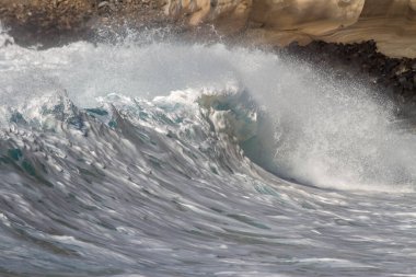 Bol köpüklü dalgalar, Atlantik Okyanusu 'nun volkanik siyah kumlu sahilinde, arka planda kayaları ve kayaları gören dalgalar. Los Gigantes, Tenerife, Kanarya Adaları 'ndan Cliff. İspanya